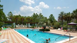 A swimming pool with lounge chairs and palm trees. - Charming, Chic, Right Next to the Beach (Santa Rosa Beach)