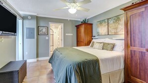A bedroom with a bed, a wooden wardrobe, a ceiling fan, and a television on the wall. - DIRECT GULF VIEW | 10TH FLOOR BALCONY |  KING BED | FREE PARKING | STEPS TO BONITA BEACH (Bonita Springs)