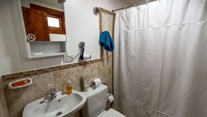 Un baño con lavabo, inodoro y cortina de ducha.