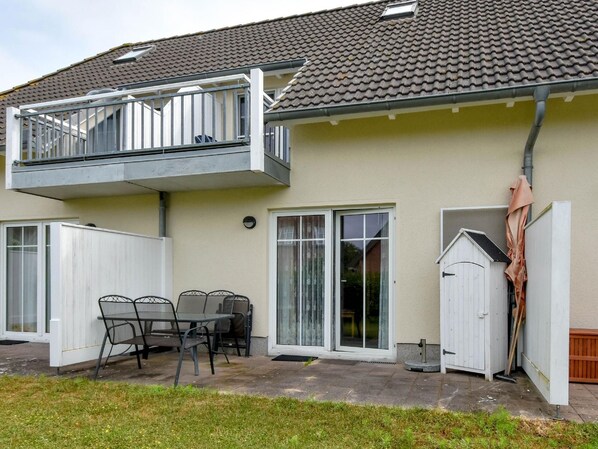 Enjoy a balcony with a patio area featuring a table and chairs, surrounded by a white fence.