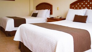 Two single beds with wooden headboards, white bedding, and brown throw blankets. - Mision Veracruz (Boca del Río)