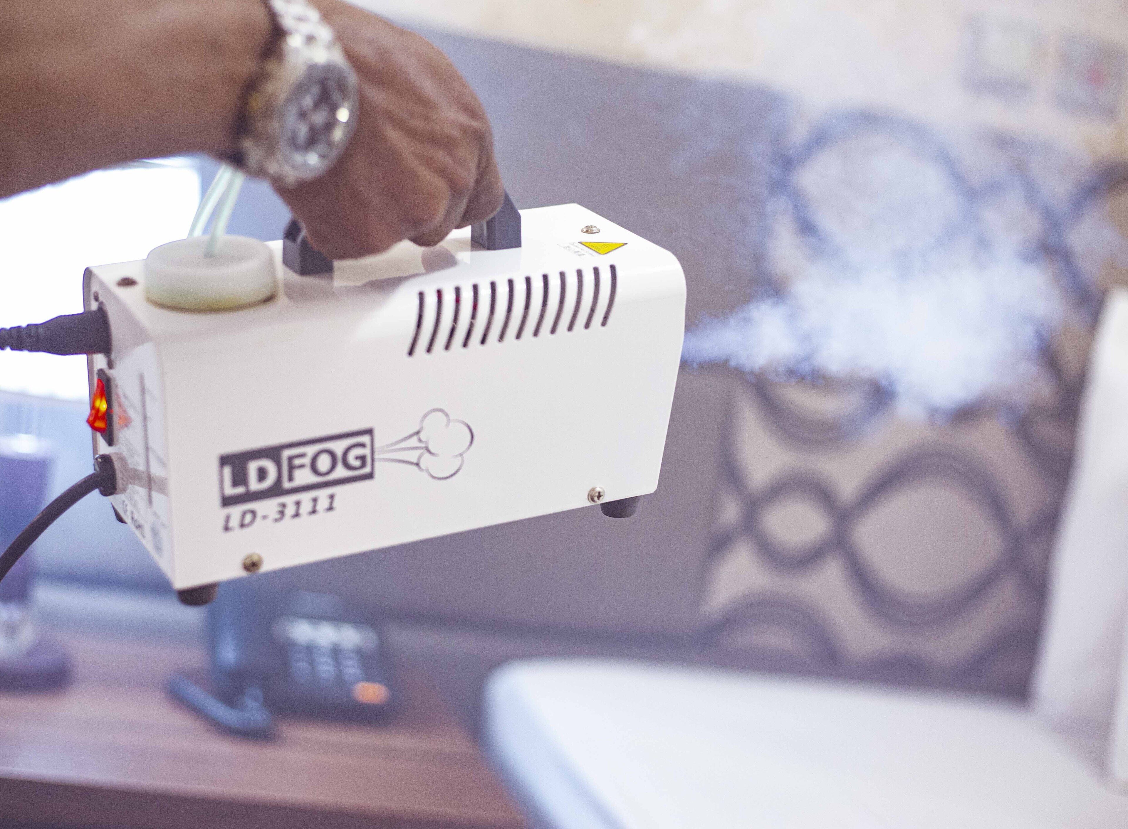Un dispositivo portatile etichettato LD-FOG LD-3111 che emette un getto di nebbia.