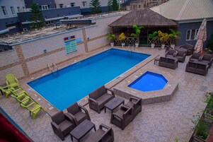 Una piscina al aire libre, sombrillas, tumbonas