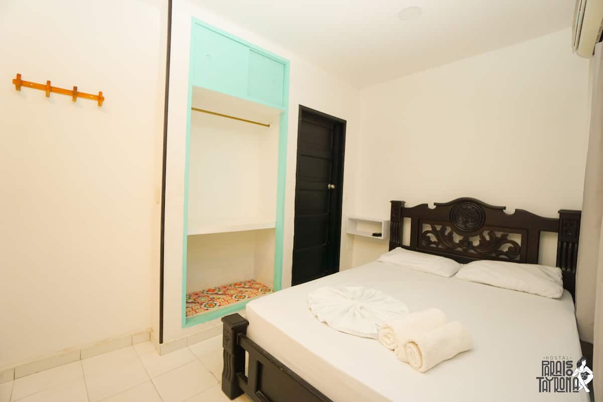 A bedroom with a bed, a wardrobe, and a door.