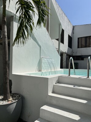 A modern building with a pool, stairs, and a palm tree. - Paraiso Tayrona Casa de Playa (Santa Marta)