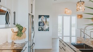 Una cocina moderna con armarios blancos, electrodomésticos de acero inoxidable y encimera de granito.