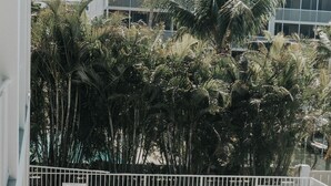 Un área junto a la piscina con sillones de descanso y un patio empedrado.
