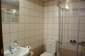 A bathroom with a sink, toilet, and shower. - Horizon Apartments Platanias (Platanias)