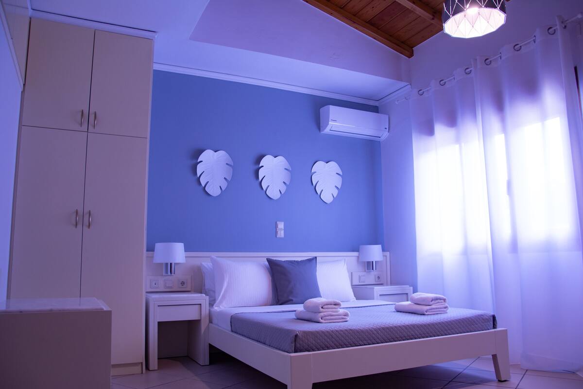 Un dormitorio con cama, mesitas de noche, un armario y decoración en la pared.
