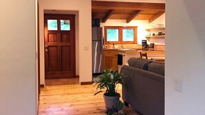 Eine Holztreppe führt zu einem Wohnbereich mit einer Couch und einem Blumentopf.