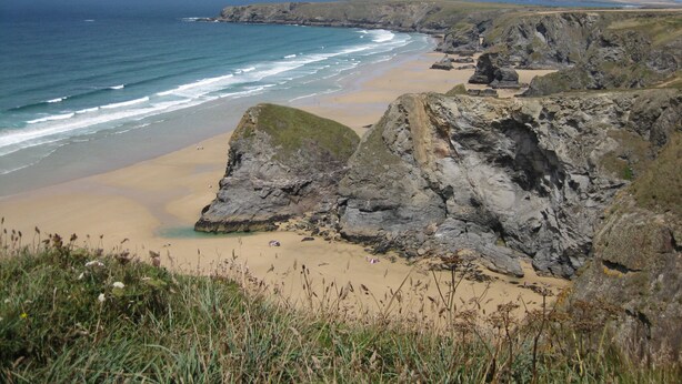 A coastal landscape with rocky cliffs, a sandy beach, and the ocean. - 3 bedroom accommodation in Wadebridge (Wadebridge)