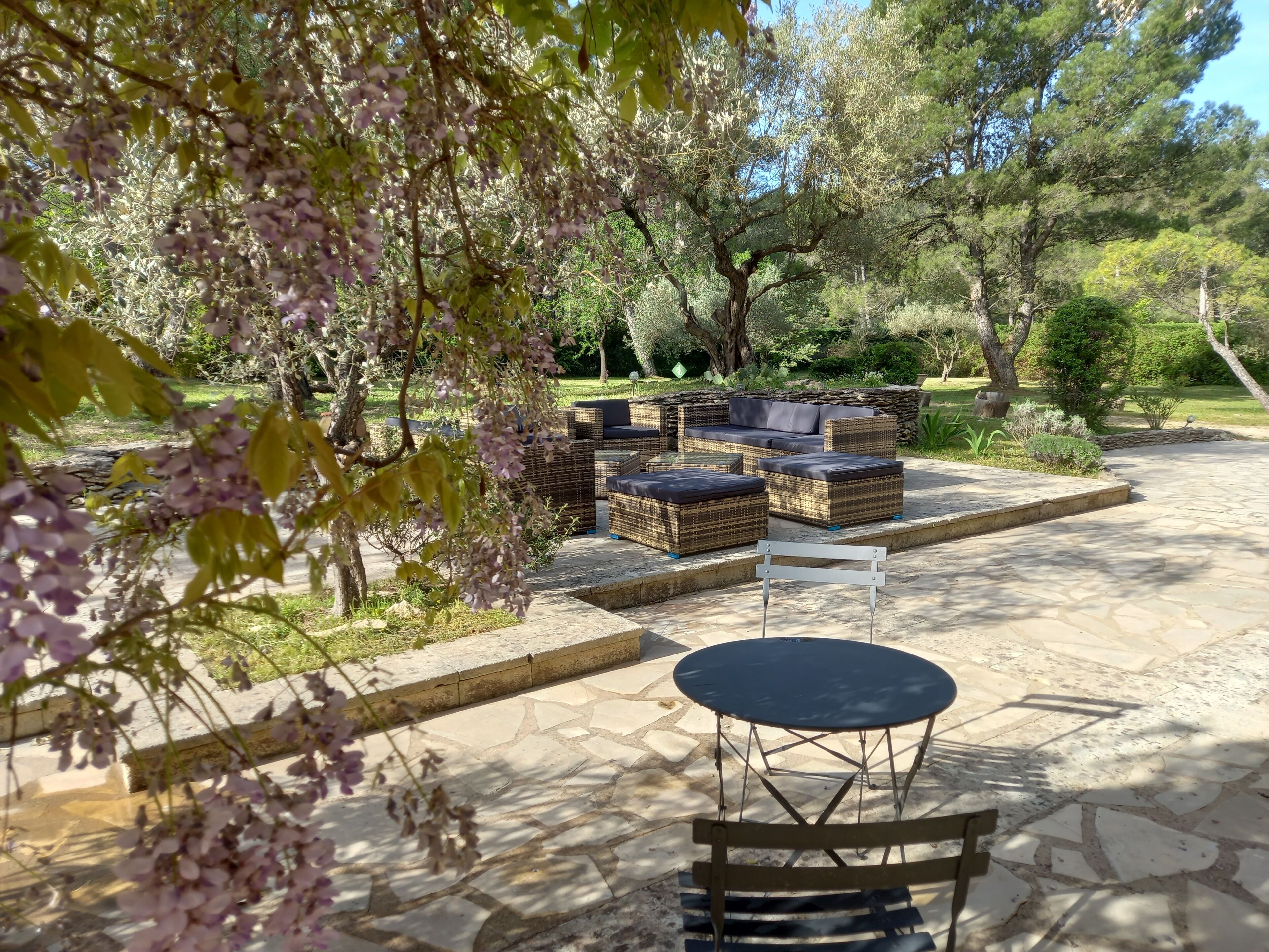 An outdoor seating area with wicker furniture and a stone patio.