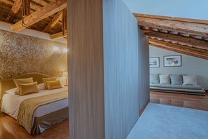 Une chambre à coucher avec un lit, une table de chevet et un mur orné de tableaux.