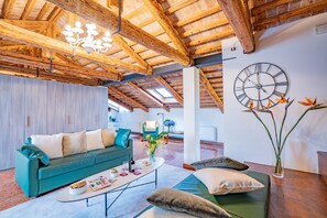 Un salon moderne comprenant un canapé, une table basse et des éléments décoratifs tels qu’une horloge et des fleurs.