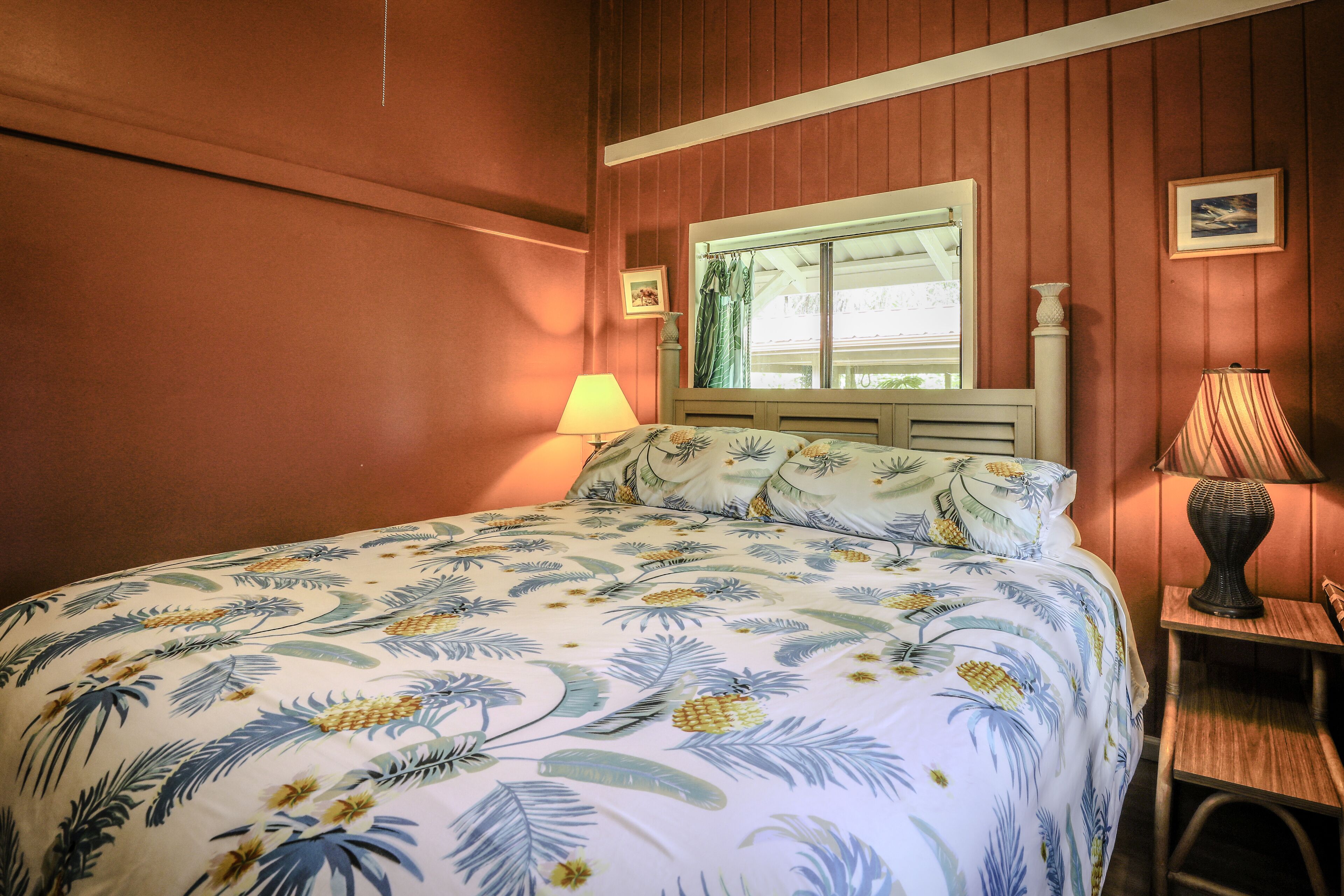 Une chambre à coucher avec un lit, une fenêtre, une lampe et un tableau au mur.