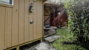 A wooden cabin with a porch and steps leading to a deck. - COZY HIDEAWAY IN THE OHIA RAINFOREST LOCATED BELOW VOLCANO NATIONAL PARK (Mountain View)