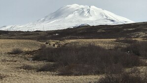 A snow-capped mountain with a barren foreground. - Afternoon Cottages near Hella, Hekla & Landmannalaugar (Hella)