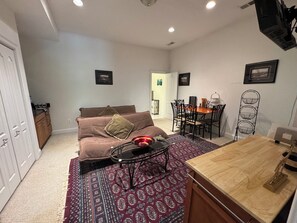 Uma sala de estar com sofá, mesa de centro e área de jantar com cadeiras e mesa.