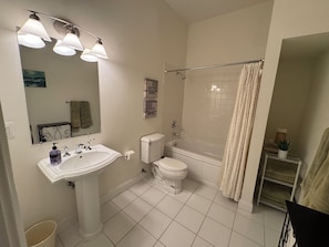 Un baño con lavamanos, inodoro y bañera.