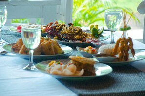 Una mesa dispuesta con diversos platos, incluyendo mariscos y un postre, junto con dos vasos de agua.