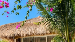 A thatched-roof outdoor area with a glass enclosure, a dining table, and a bed visible through the glass. - Samalas Boutique Hotel resort & Private Pool Villas (Gili Meno)