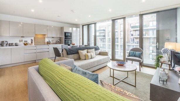 Un apartamento moderno con cocina, sala de estar y amplios ventanales.