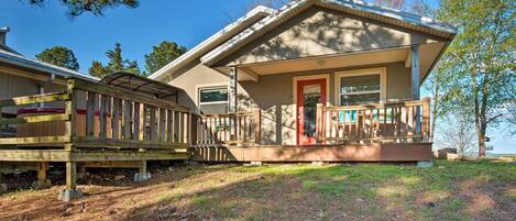 A two-story house with a covered porch and a small deck.