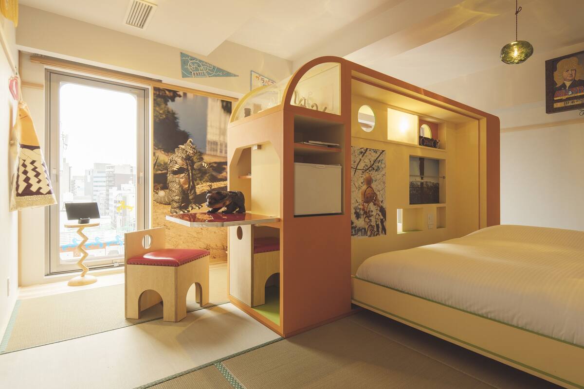 A room with a bunk bed, a desk with a chair, and a small window.