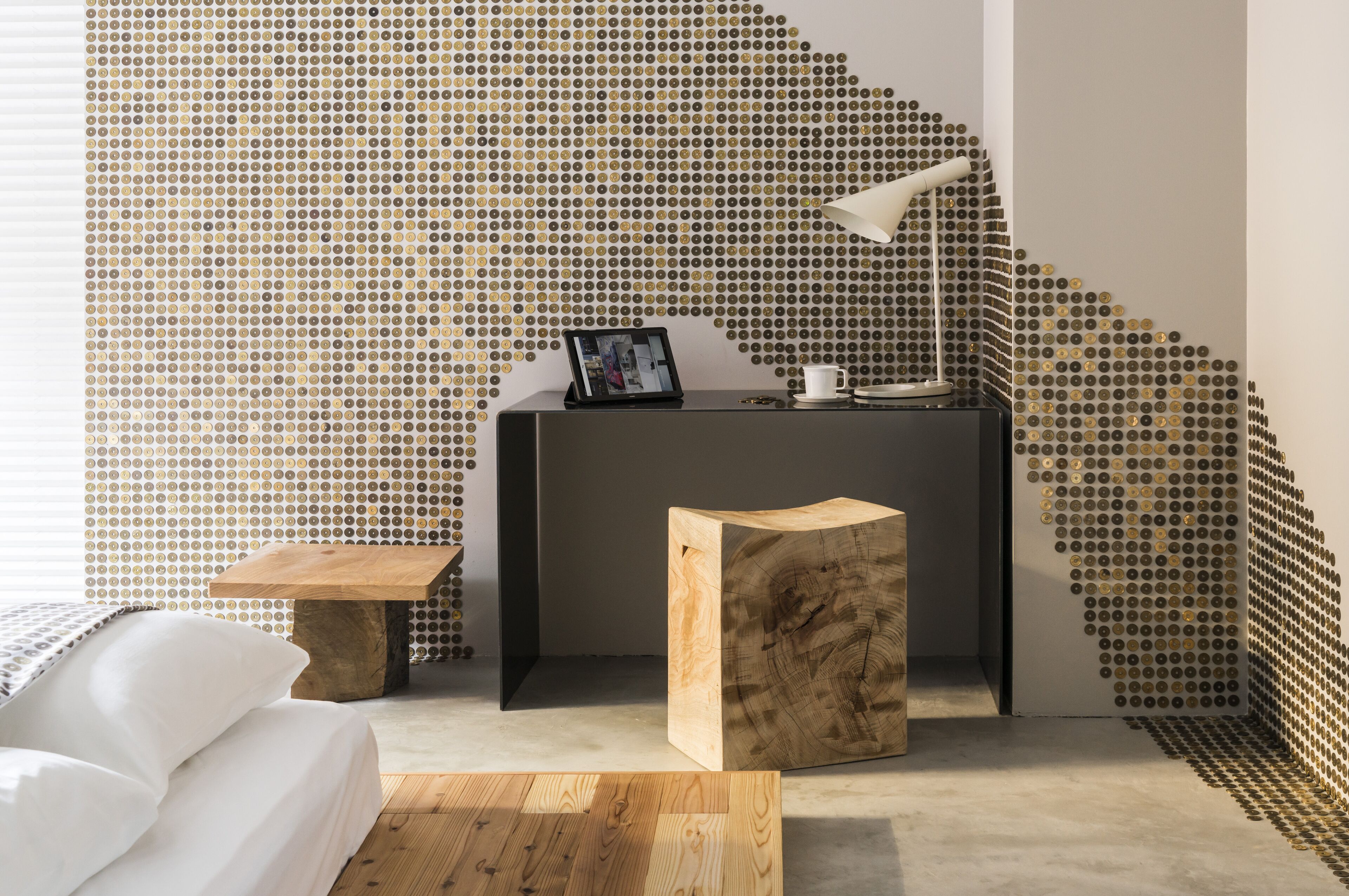 Une chambre moderne avec un mur à motifs, une table d’appoint en bois, une table de chevet et un lit.