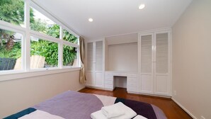 A bedroom with a bed, a desk, and a wardrobe. - Takapuna Central Spacious & New Home (Auckland)