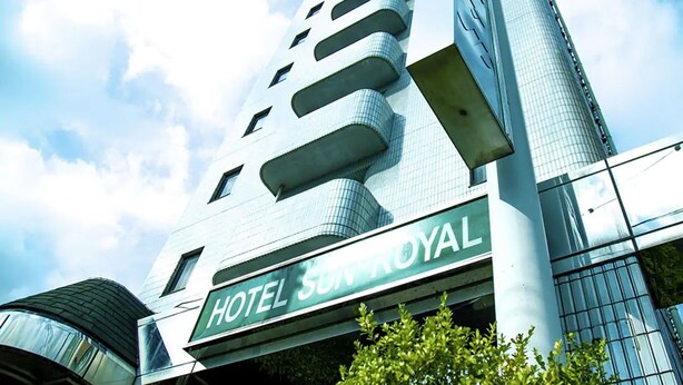Un moderno edificio de hotel con un cartel llamativo que dice "HOTEL SUNROYAL".
