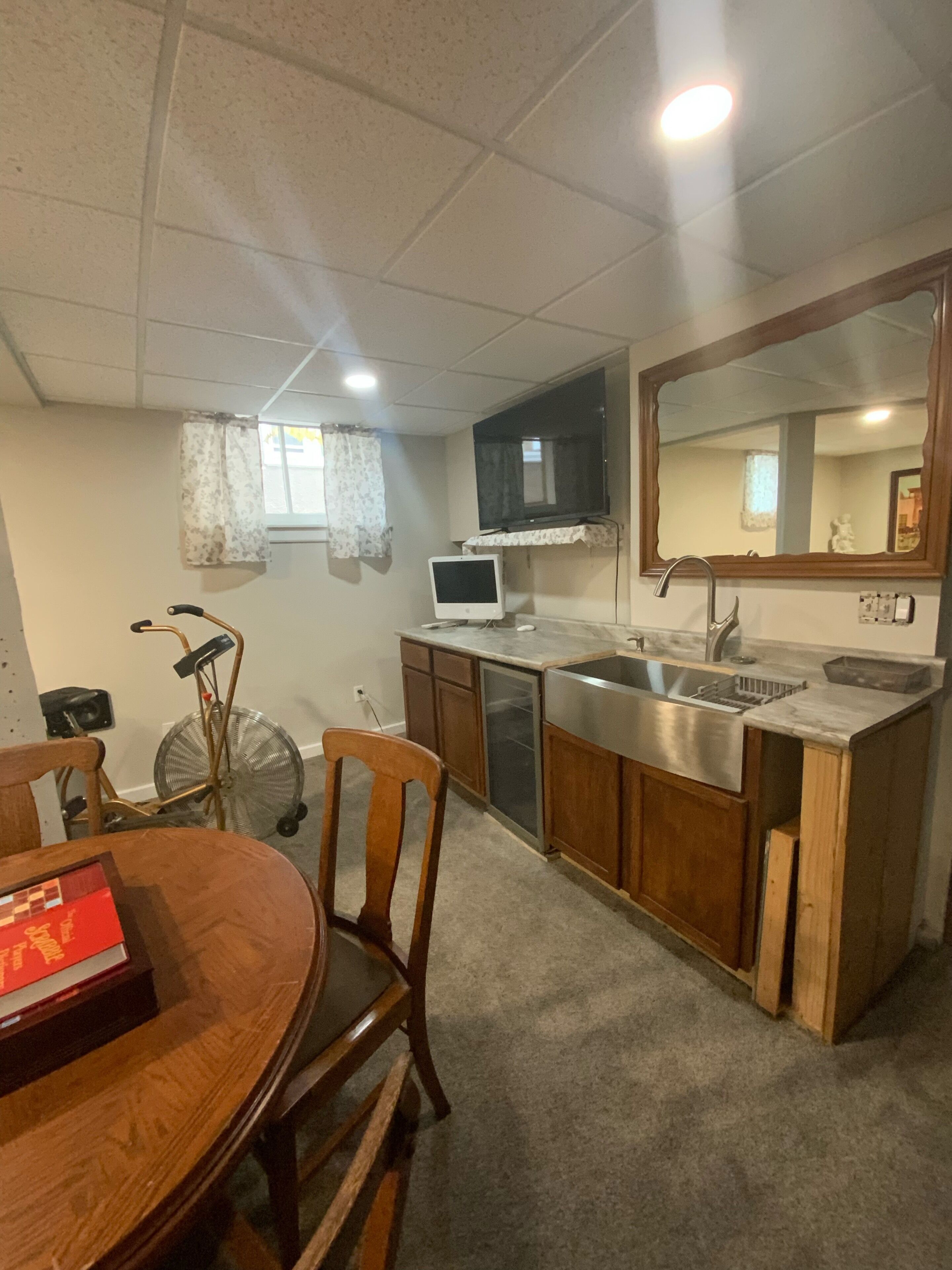 Una cocina compacta con comedor, un espejo grande y un ventilador de techo.