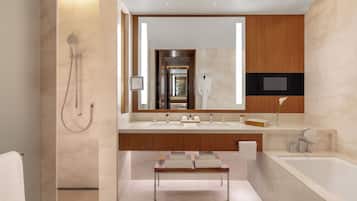 Un baño moderno con un espejo grande, una bañera y una ducha.