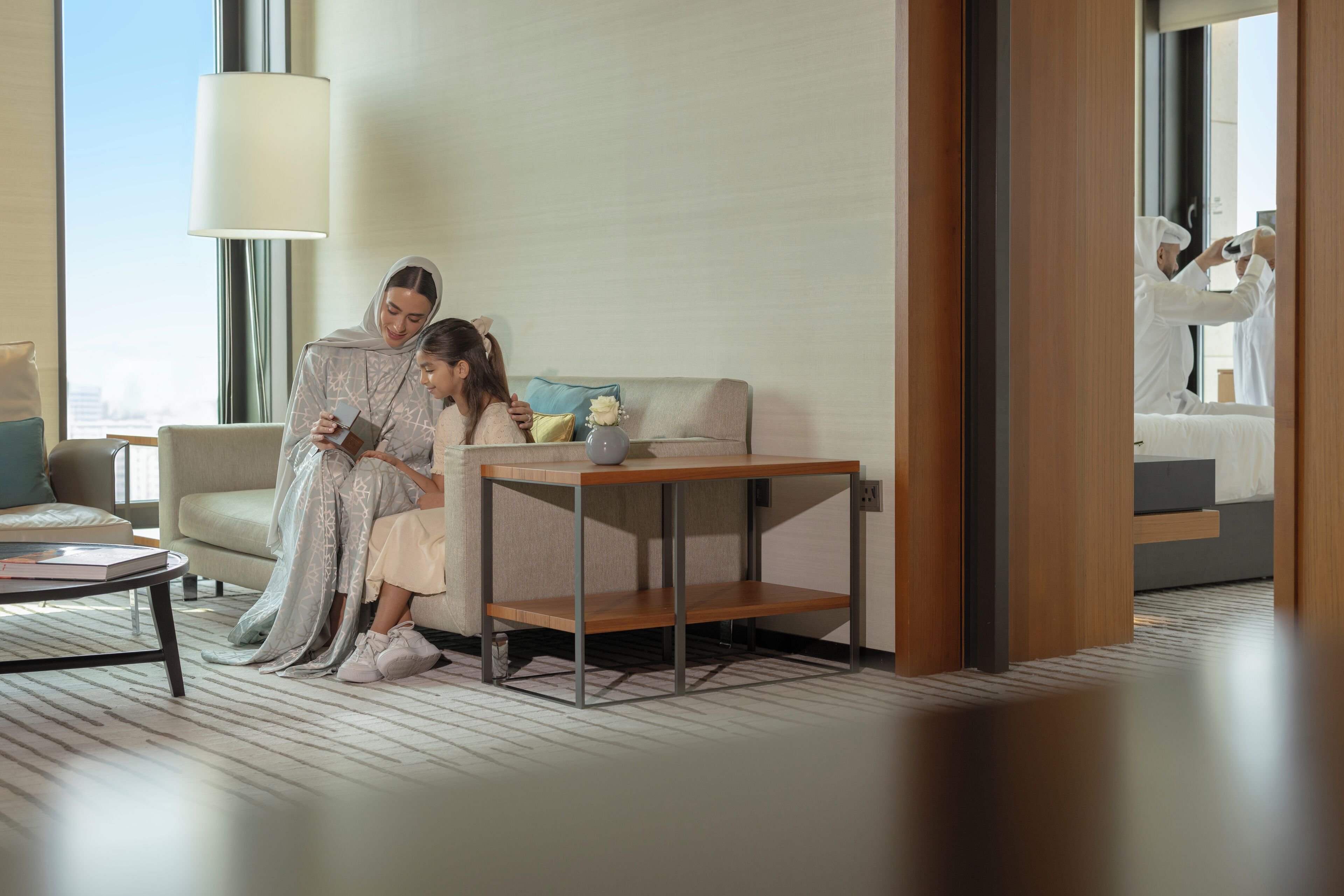 Una habitación de hotel moderna con sofá, una mesita y una lámpara.
