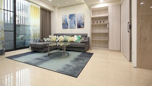 A modern living room with a grey sofa, a glass coffee table, and abstract wall art. - 52Travelers Home (Hualien City)