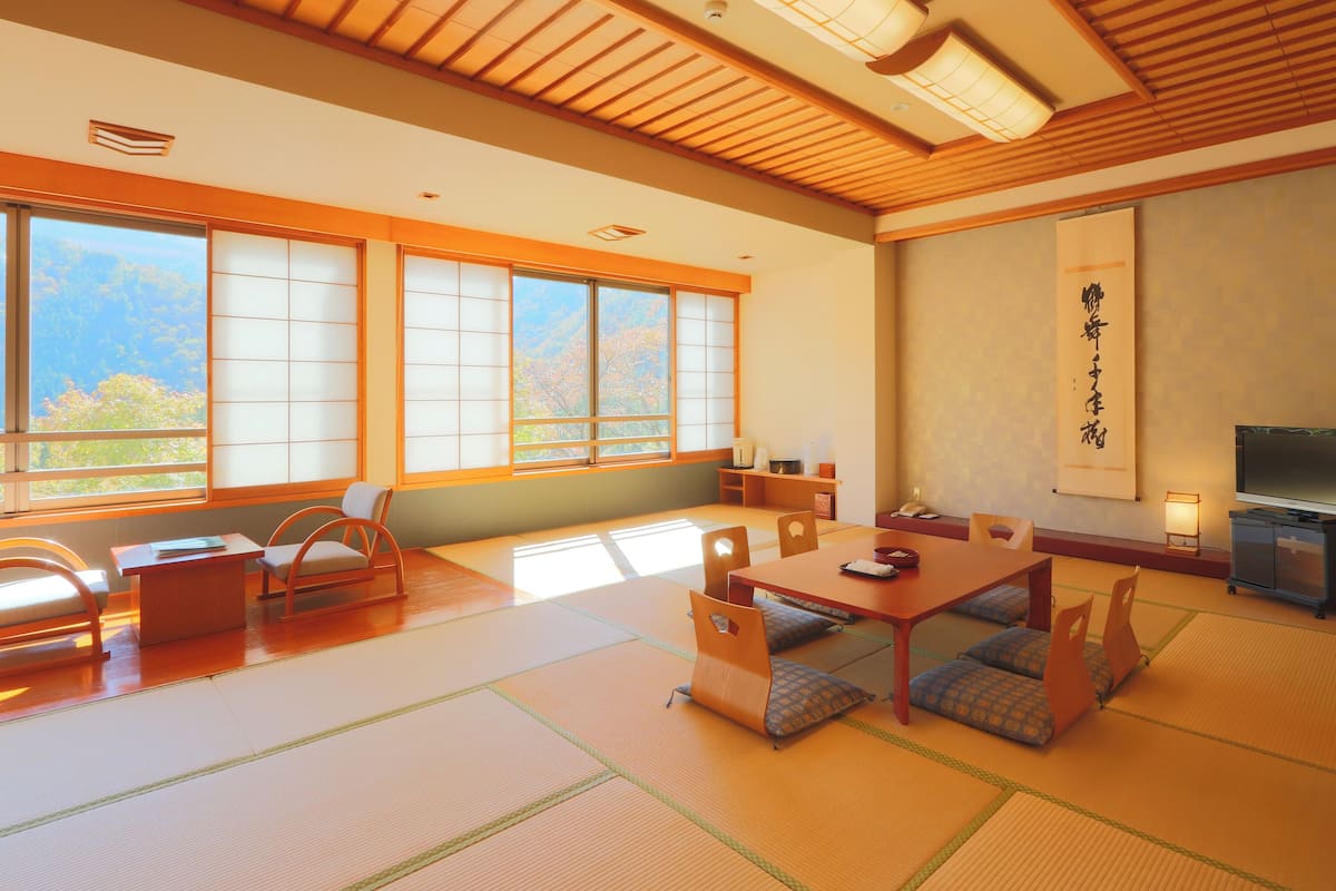 A traditional Japanese room with tatami flooring, a low table, and sliding doors.