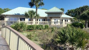 A two-story building with a light green roof, a covered porch, and a white railing. - SHIPYARD - WALK TO BEACH & STEPS TO POOL.  Bright corner unit & golf course view (Hilton Head Island)