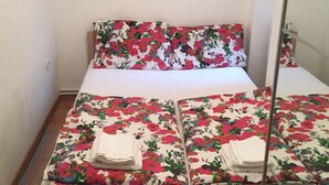 A bed with floral bedding, a mirror, and a painting of trees on the wall. - Apartment in town centre,beautiful and quiet,ideal for families and couples (Zagreb)