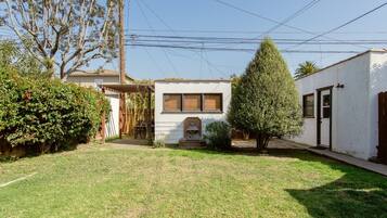 A residential property with a well-maintained lawn, a wooden pergola, and a small garden area.