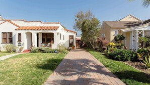 A residential street with two houses, a paved walkway, and well-maintained lawns. - Casita Gundry- Boutique Hideaway, Quaint Historic Charm (Long Beach)