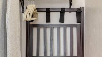 Un banc en bois doté d’un dossier à lattes et d’une étagère inférieure, un porte-serviettes suspendu avec des serviettes pliées, et un tiroir en bois situé en dessous.