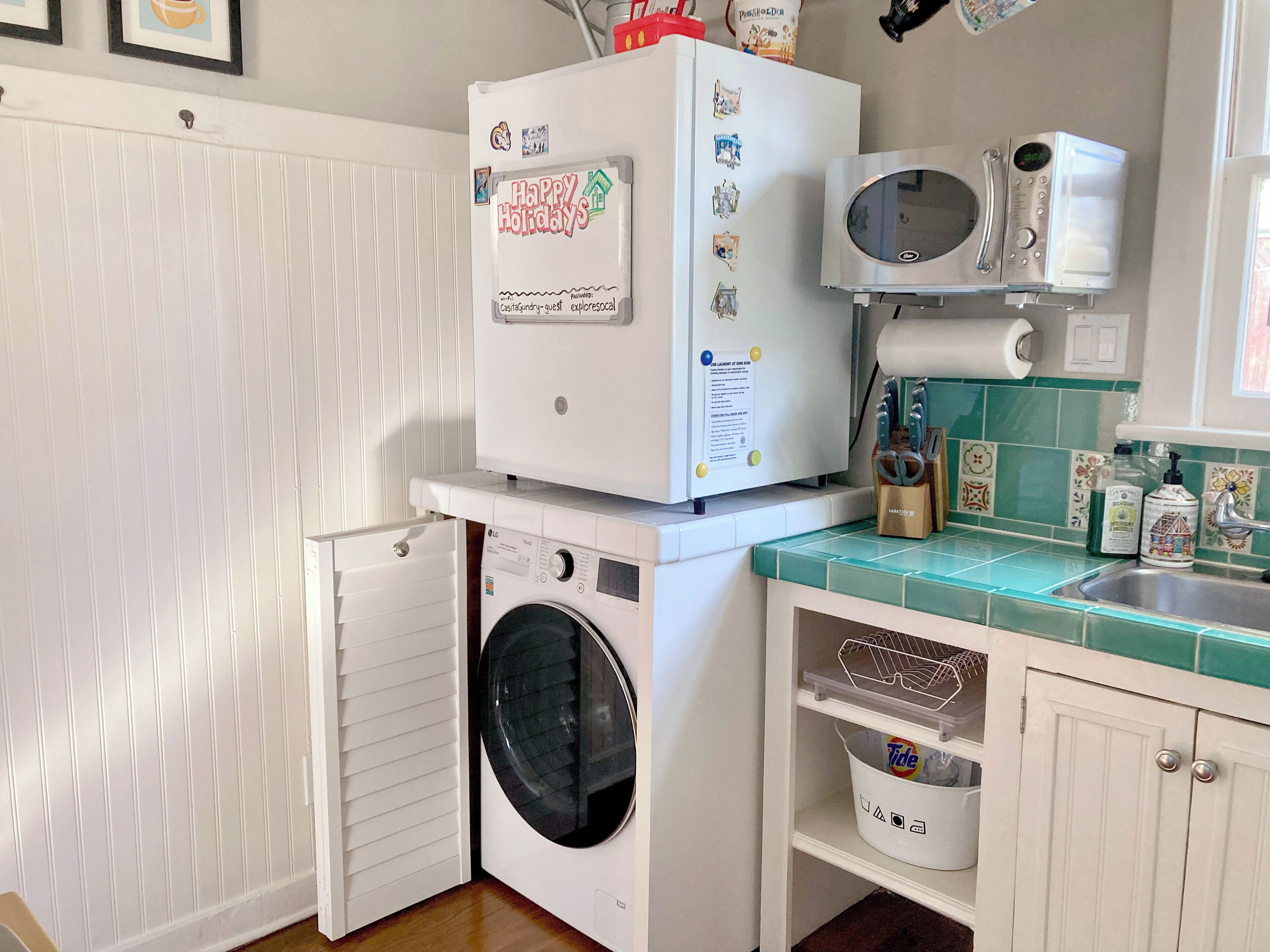 A compact laundry room with a washing machine, a dryer, and a microwave.