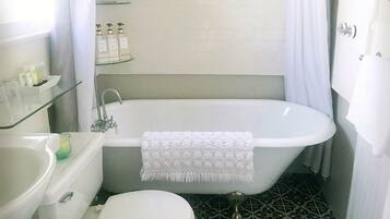 A bathroom with a freestanding bathtub, a toilet, and a sink.