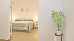 A bedroom with a bed, bedside tables, and a potted plant.
