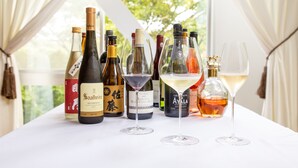A table with various wine bottles and glasses, likely in a hotel setting.