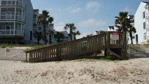 A wooden boardwalk leading to a beachfront property with a private property sign. - NEW LISTING Day Break at SeaScape #2219: A Place to Rest, Relax, and Rejuvenate! (Galveston)