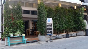 Une auberge de jeunesse avec un panneau indiquant les équipements disponibles, tels qu’un dortoir mixte, un dortoir réservé aux femmes, une chambre privée, un espace de stockage pour les bagages, un petit-déjeuner gratuit, une connexion Wi-Fi gratuite et des casiers gratuits.