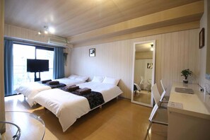 A hotel room with two beds, a TV, a desk with a laptop, and a large window. - F apt 202 Mickey House SHIBUYA SHINJUKU (Tokyo)