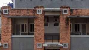 Un edificio con fachada de ladrillo, varias ventanas y un balcón.