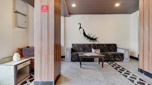 Un vestíbulo moderno con una zona de estar, un cartel de 'No Fumar' y un mural decorativo.